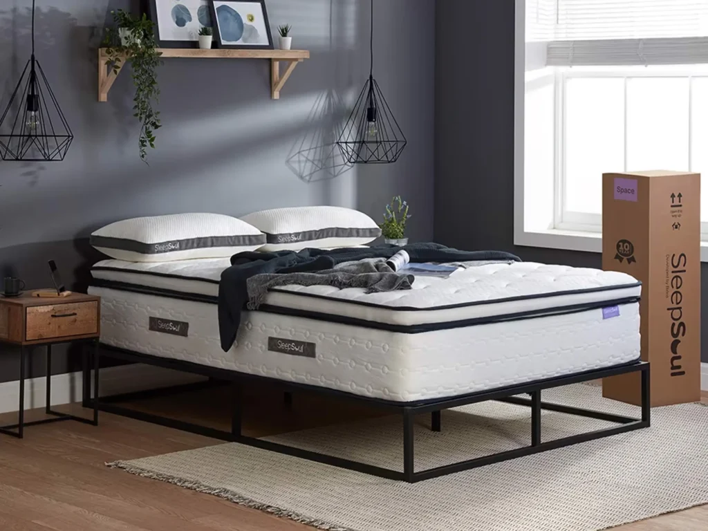 A SleepSoul Space mattress on a black metal bed frame in a modern bedroom with stylish decor.