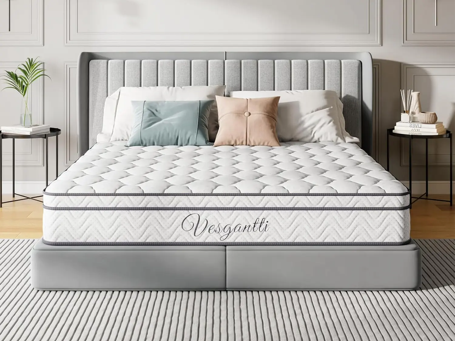 Vesgantti Hybrid Mattress with white quilted top and grey chevron-patterned sides displaying the Vesgantti logo, presented on a grey platform bed frame with a tall channelled headboard in a bright, modern bedroom.