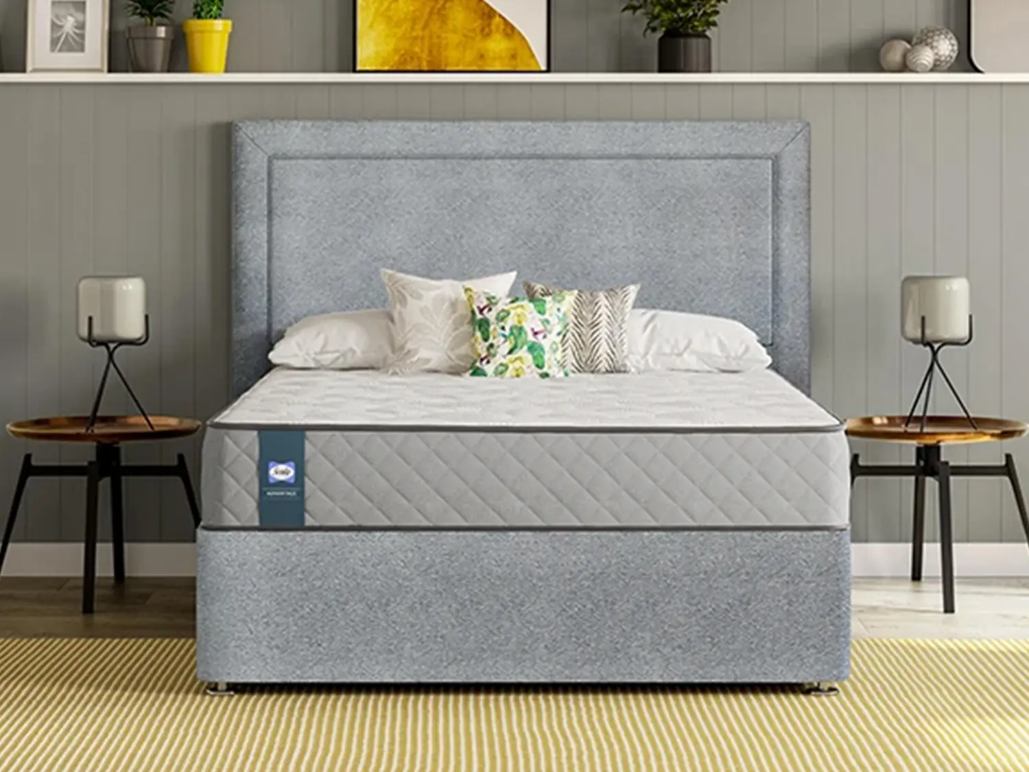 Sealy Advantage Memory Essential mattress on a light grey divan base with a matching border-style headboard in a modern bedroom.